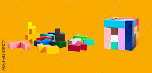 Картината върху платно Wooden puzzle pieces and cube on orange background