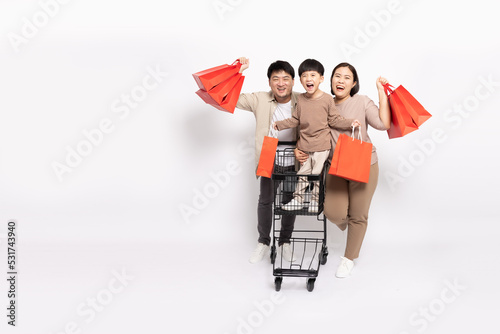 Happy Asian family holding shopping bag with shopping trolley isolated on white background, Family and shopping mall concept