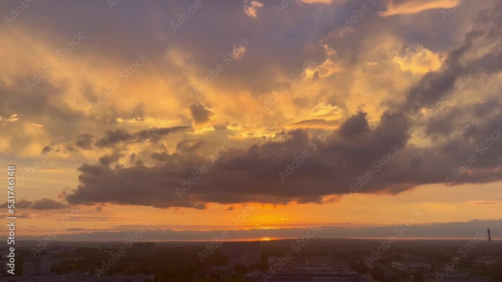 Sunset sky with changing clouds and sun, evening city, city landscape. Beautiful cloudy sunset. Natural light and darkness. Faster motion. Sky Timelapse.