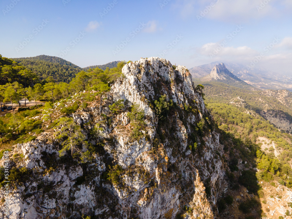 Beautiful natural landscape. Cyprus mountains and blue sky with clouds. Nature background. Forest of green trees. Top view from a drone. Exotic island.