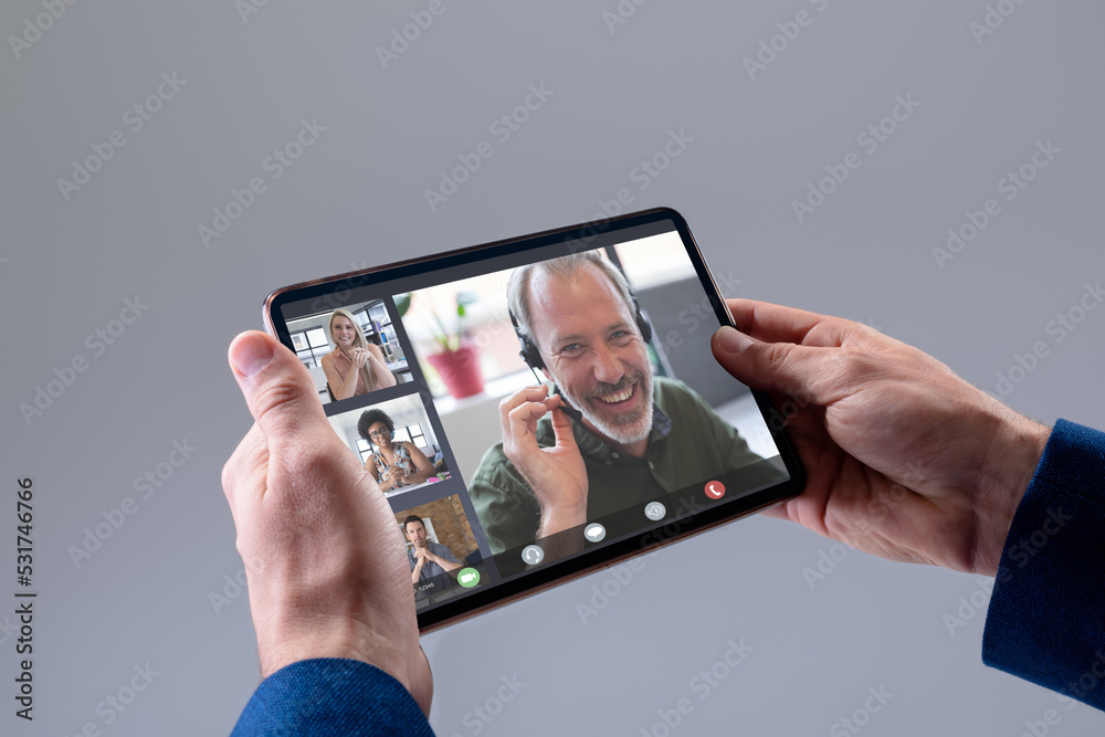 Cropped hands of businessman video conferencing with multiracial coworkers over digital tablet