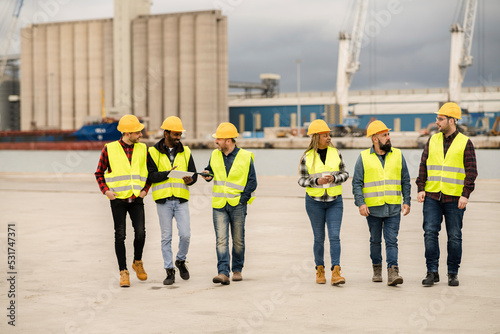 group of multiracial co-workers walking through the port of goods, engineers and warehouse workers.