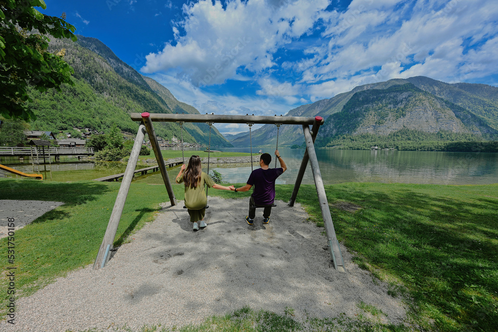 Fototapeta premium Couple swinging holding hands at Hallstatt, Austria.