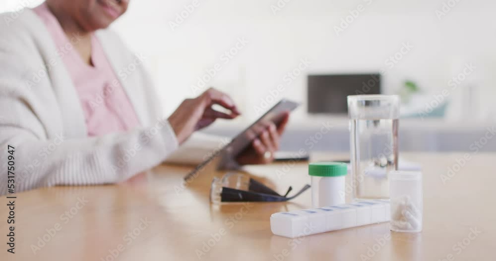 Portrait of senior african american woman sitting at table, using tablet Portrait of senior african american woman sitting at table, using tablet