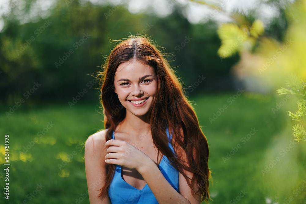 Portrait of a young woman with a beautiful smile in nature on a background of greenery in the spring on a sunny day, the beauty of health and youth, happiness Portrait of a young woman with a beautiful smile in nature on a background of greenery in the spring on a sunny day, the beauty of health and youth, happiness
