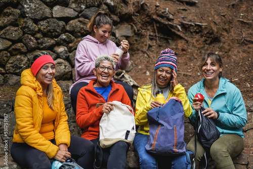 Group of multiethnic women having fun during trekking day at mountain forest - Multi generational female friends smiling on camera outdoor