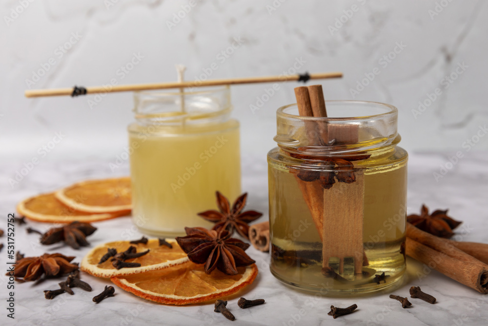 Set for making candles on a wooden background. Pouring soy wax into glass. Candles with dried flowers and spices. Eco soy wax on a white table. Candle with your own hands. Hobby concept.Place for text