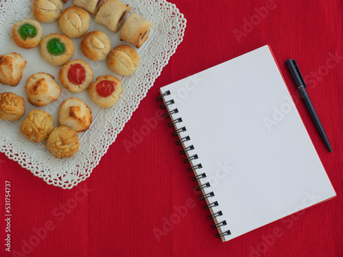 Homemade sweet panellets dessert, a typical pastry from Catalonia, Spain, on the All Saints festival. Notepad and pen for copy space photo