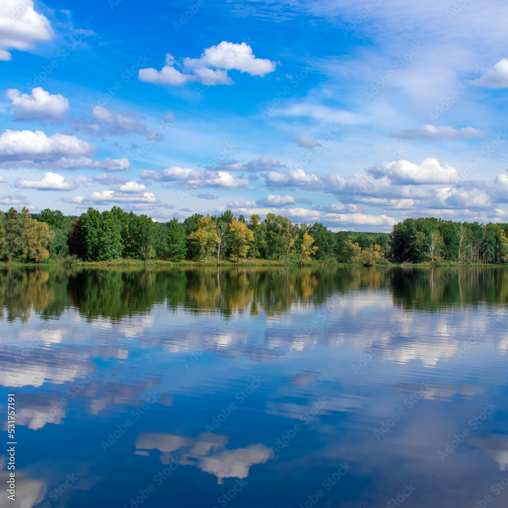 Autumn landscape. Mirror reflection of the autumn forest in the river water Autumn landscape. Mirror reflection of the autumn forest in the river water