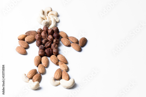 Figure of cashew and almond nuts in the shape of a man. Symbol of natural healthy food. Isolated figure on a white background