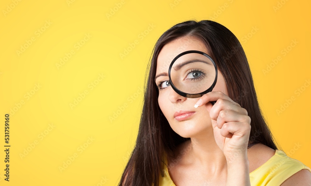Young woman with magnifying glass in her hand Young woman with magnifying glass in her hand