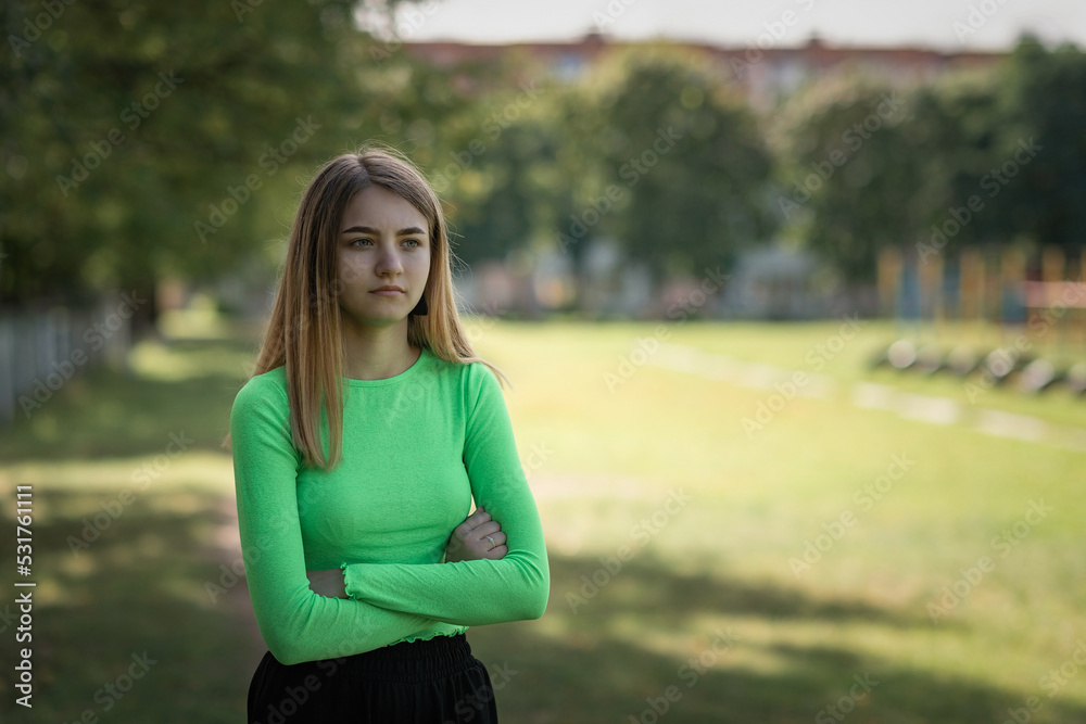 Portrait of a young beautiful girl in a green blouse and black parka pants. Portrait of a young beautiful girl in a green blouse and black parka pants.