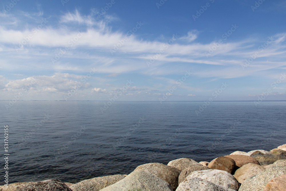 Öresund strait on a calm summer day with clear blue sky seen from rocky coast