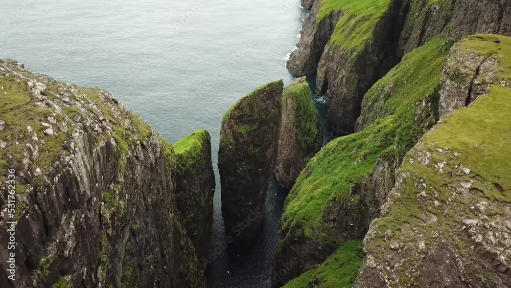 Aerial drone view of Dunnesdrangar, Faroe Islands. Amazing nature, huge cliffs and mountains in Faroe Islands. Vagar Island. Many flying sea birds. Sunny day in summer. High quality 4k footage. Aerial drone view of Dunnesdrangar, Faroe Islands. Amazing nature, huge cliffs and mountains in Faroe Islands. Vagar Island. Many flying sea birds. Sunny day in summer. High quality 4k footage.