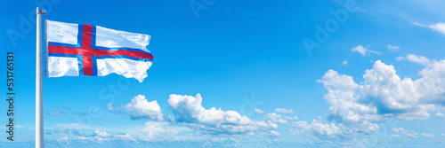 Faroe Islands flag on a blue sky *** Horizontal banner 12000 x 4000 px