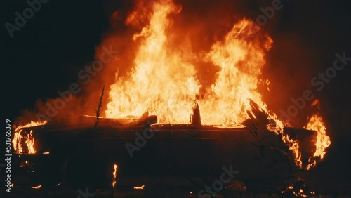 On street burning car in the city. Orange fired. Automobile engulfed in flames of fire. Explosion. Bomb. Car crash. Burning wheel. Emergency