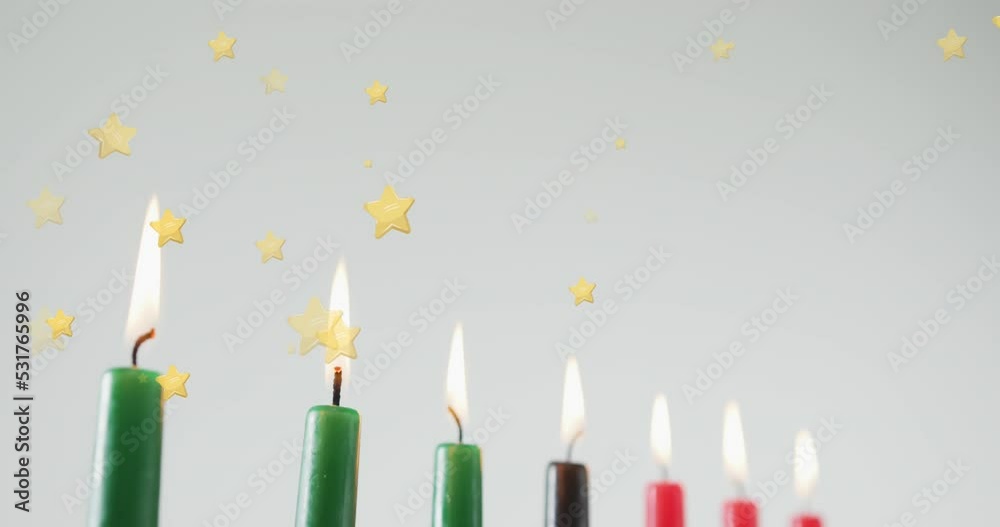 Animation of golden stars falling over kwanzaa candles on grey background Animation of golden stars falling over kwanzaa candles on grey background