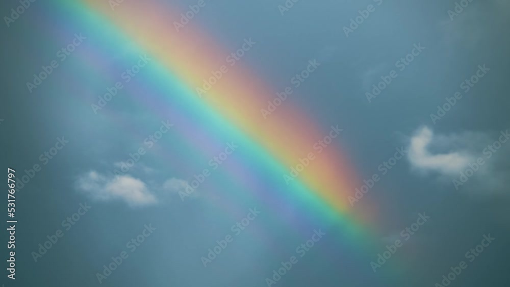 Beautiful shot of blue dark sky with rainbow. Weather. Colorful. Cloudspace. Natural