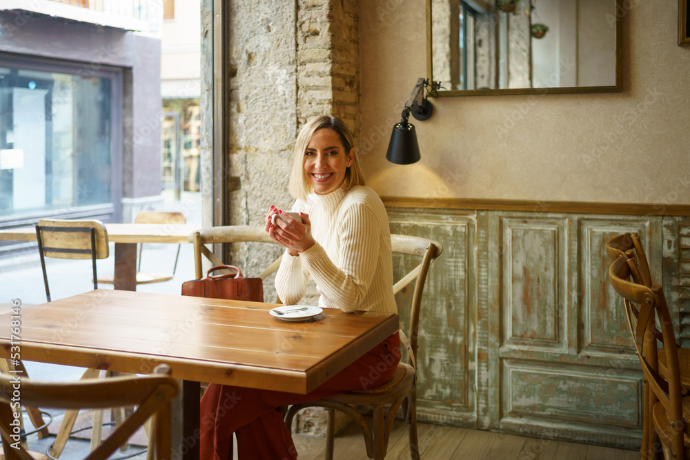 Joyful woman with coffee in cafeteria Joyful woman with coffee in cafeteria