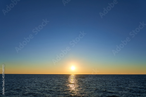 Sunset in the sea. The sun slowly goes behind the sea line