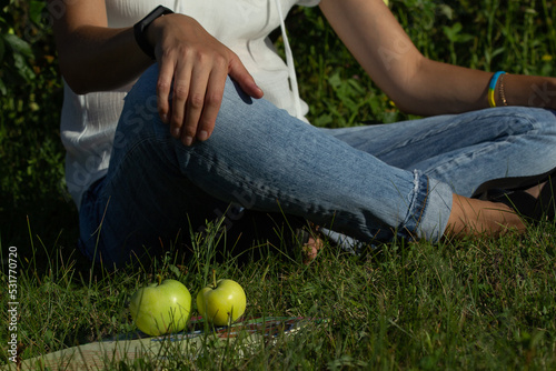 white apples lie on a book, woman sitting back