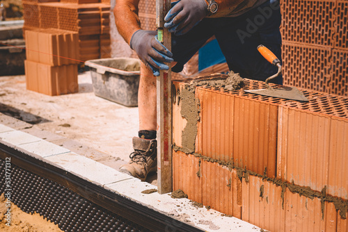 Professional construction worker laying bricks and mortar - building external house walls Fototapet