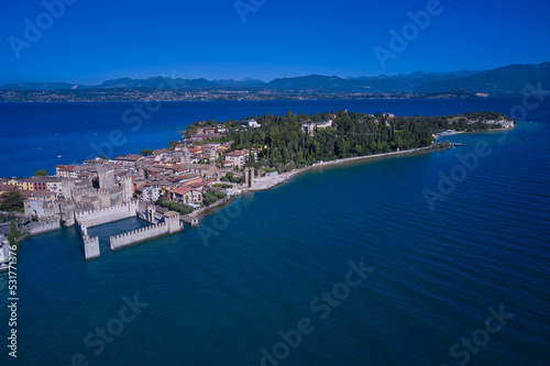An ancient village on southern Garda Lake. Aerial view on Sirmione sul Garda. Italy, Lombardy. View by Drone. Rocca Scaligera Castle in Sirmione.