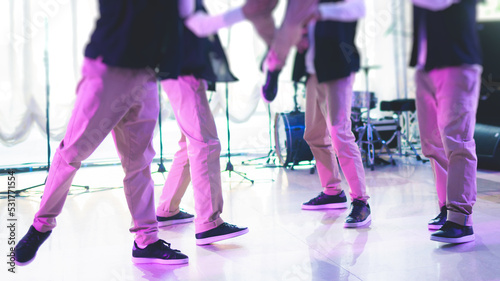 Group of hip-hop dancers performance on a stage, modern contemporary street dance with break dancing in studio, hip hop dance training in a ballroom, legs in sneakers close up