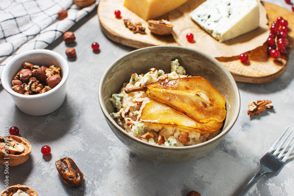 Pear and gorgonzola oatmeal with walnuts on concrete table Pear and gorgonzola oatmeal with walnuts on concrete table