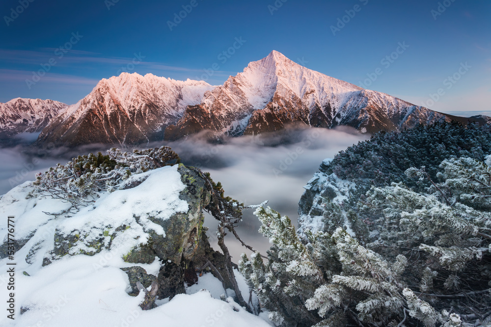 Winter landscape with mountain Krivan in High Tatras illuminated by morning sun. Natural scenery with hills covered by snow in high altitude of national park in Slovakia.