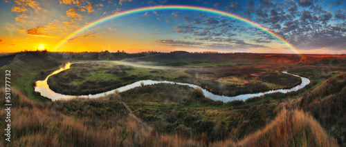 Amazing rainbow over the small rural river. autumn morning. nature of Ukraine