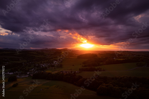 Aerial view of the countryside in the warm tones of sunset in Germany, dramatic sky