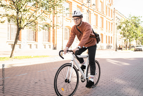A male cyclist in a helmet rides a bicycle to work in the city, ecotransport.