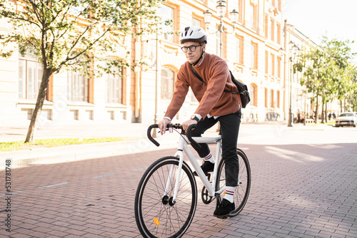 A male cyclist in a helmet rides a bicycle to work in the city, ecotransport. photo