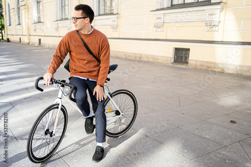 Fototapeta Naklejka Na Ścianę i Meble -  A male cyclist rides a bicycle to work in the city, ecotransport.