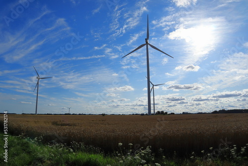 Wind power turbines at a meadow. Windy weather one summer day outside. Modern Swedish farm land. Near Skara, Sweden, Scandinavia, Europe. Year 2022.