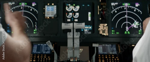 Commercial aircraft pilots controlling airplane throttle lever during the flight or take off. View from inside the cabin. Real aircraft, daytime shot