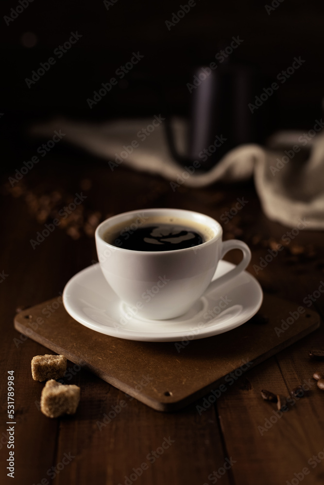 Cup of coffee and kettle beans at wood table Cup of coffee and kettle beans at wood table