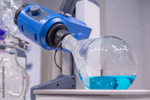 Laboratory rotary evaporator - homogenization process - rotating chemical glass flask for separating solid material from liquid at pharmacy lab, medical exhibition. Pharma, Chemistry, science concept photo