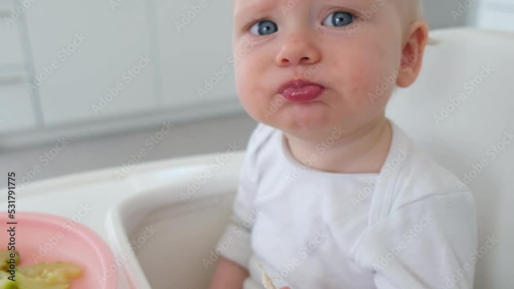 Young baby emotions portrait. Cute cheerful child eating. Slow motion video Young baby emotions portrait. Cute cheerful child eating. Slow motion video
