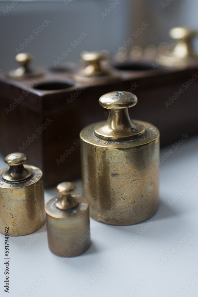 Three units of weight measure. Set in a wooden box in the background Three units of weight measure. Set in a wooden box in the background
