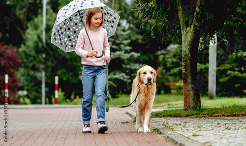 Preteen girl with golden retriever dog