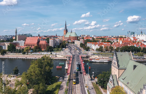 Aerial summer cityscape of Szczecin old town, Poland. Tram crossing the bridge to the over Oder river, Szczecin Cathedral (Polish: Bazylika archikatedralna św. Jakuba w Szczecinie) in the background