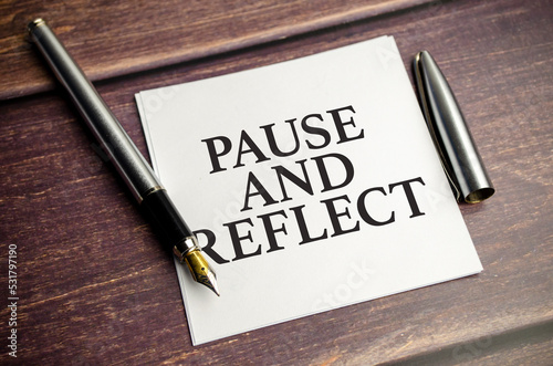 pause and reflect the phrase on white paper and pen
