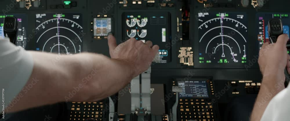 DOLLY IN Commercial aircraft pilots controlling airplane throttle lever during the flight or take off. View from inside the cabin. Real aircraft, daytime shot