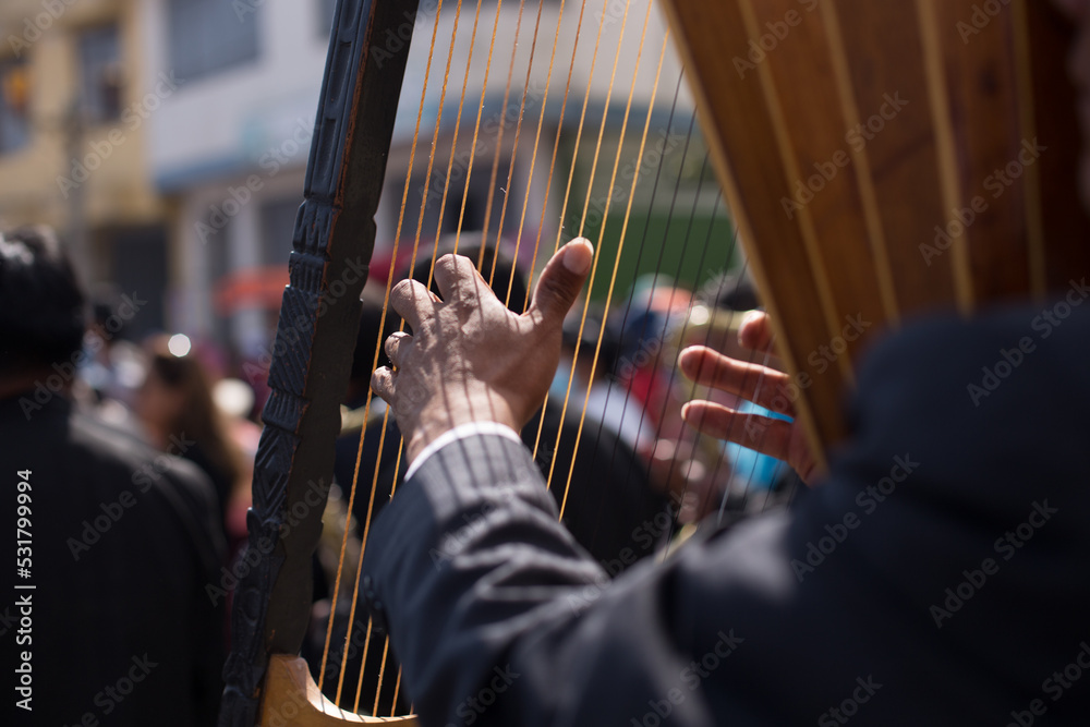 hands playing a harp in a traditional festival in peru. Concept of music and traditions.