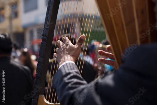 hands playing a harp in a traditional festival in peru. Concept of music and traditions.