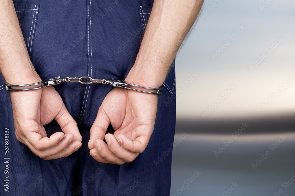 Human hands in handcuffs for criminal concept.