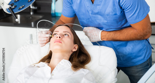 Young woman receiving innovative anti-aging carboxytherapy procedure for face skin in aesthetic medicine office, infusing of carbon dioxide under skin for collagen boosting