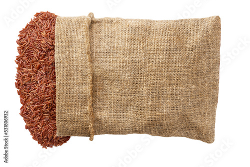 Grains are scattered out of the bag top view. red rice in sack isolated on white background flat lay.